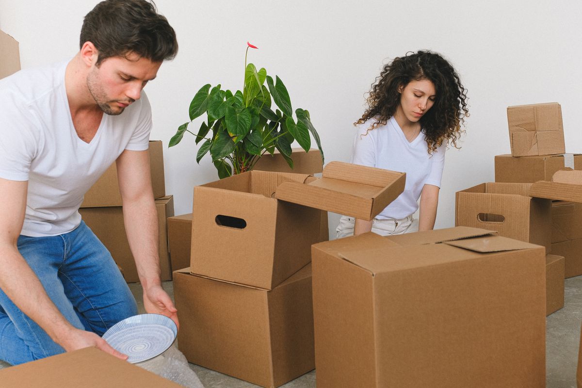 A couple packing cardboard boxes for a move
